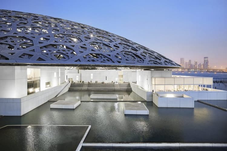 Exterior view of Louvre Abu Dhabi with its iconic dome and waterfront setting.