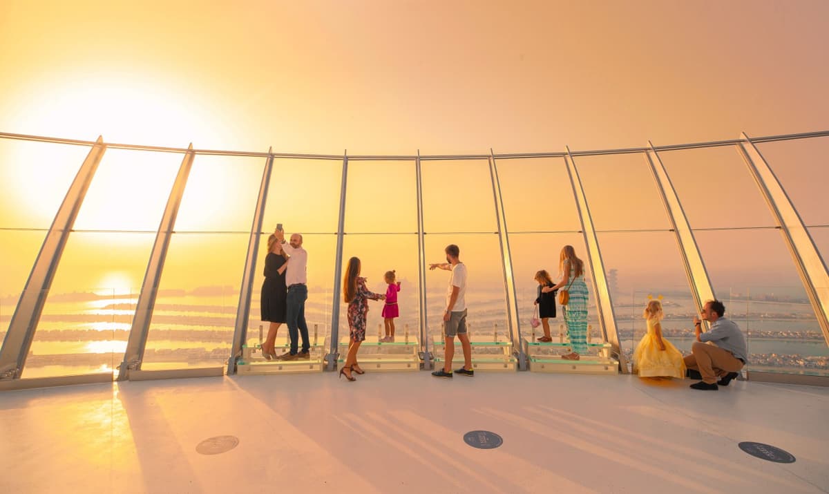 Sunset view from The View at The Palm Jumeirah observation deck with golden light over the island and sea.