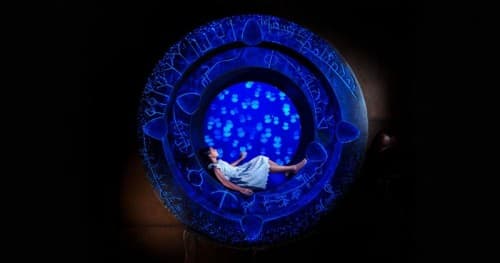 Aqua Trek Xtreme Girl Jelly Fish exhibit, a girl sits in a circle illuminated by blue lights
