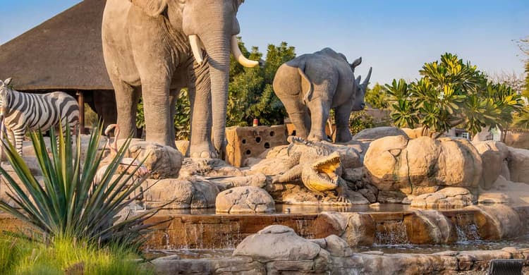 Various animals gathered in one area at Emirates Zoo Park with visitors observing them.