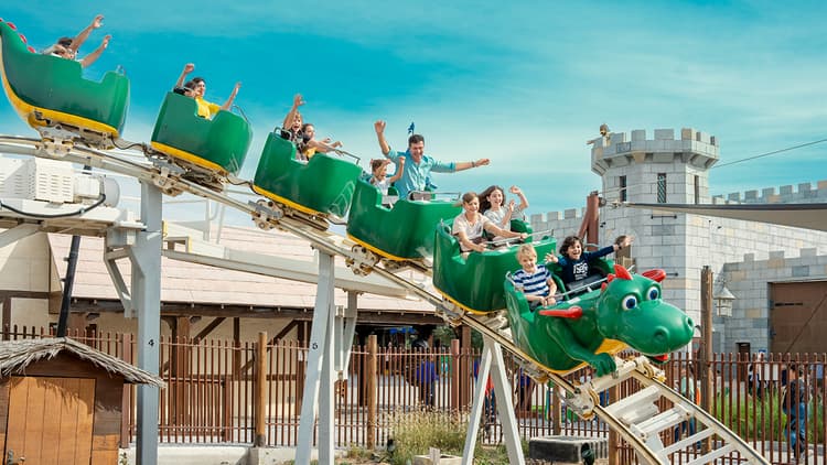 A group of people enjoying a thrilling ride on a roller coaster at Dubai Parks and Resorts.