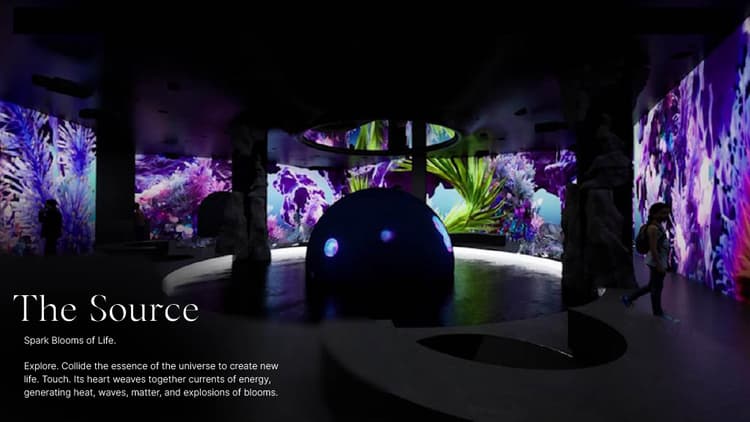 Visitors exploring The Source installation at Aya Universe with glowing light columns and immersive digital effects