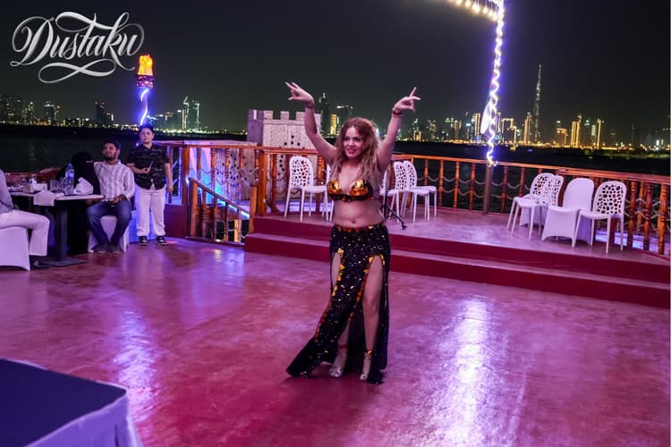 A woman in a belly dance costume performs on a boat during the Dustaku Dinner Dhow Cruise.