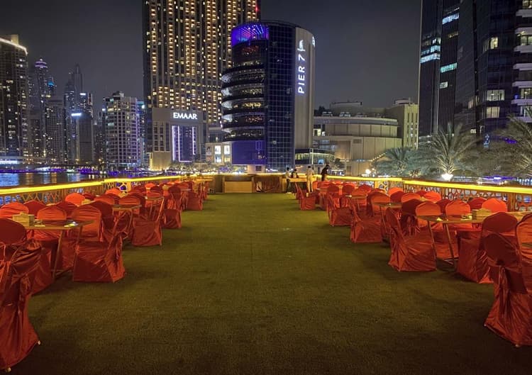 Open-air upper deck seating on a Dubai Mega Dhow dinner cruise