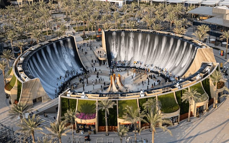 A circular fountain surrounded by greenery in the center of Expo City Dubai park.