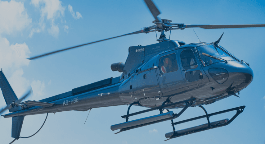A private helicopter flying in the clear blue sky during a scenic tour.
