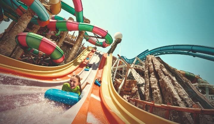 Exciting water slides and rides at Yas Waterworld Abu Dhabi with guests enjoying the attractions.