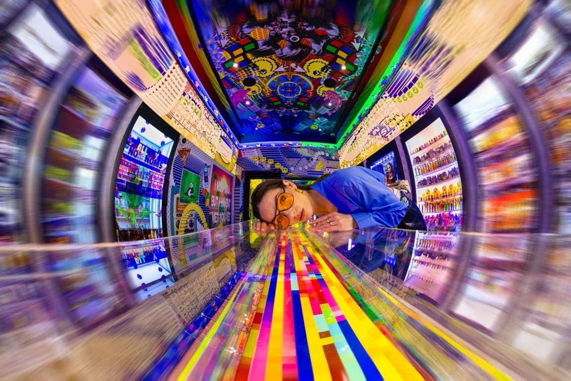 A man stands in front of a vending machine at House of Hype in Dubai, contemplating his snack choices.
